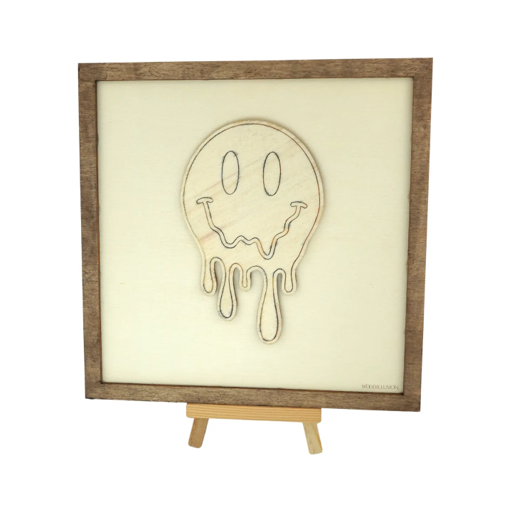Customizable wall art frame of a melting smiley in cut and engraved wood front view with easel Woodillusion