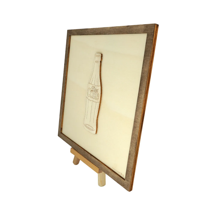 Tableau cadre personnalisable d’une bouteille Coke en bois découpé et gravé vue de profil avec chevalet Woodillusion